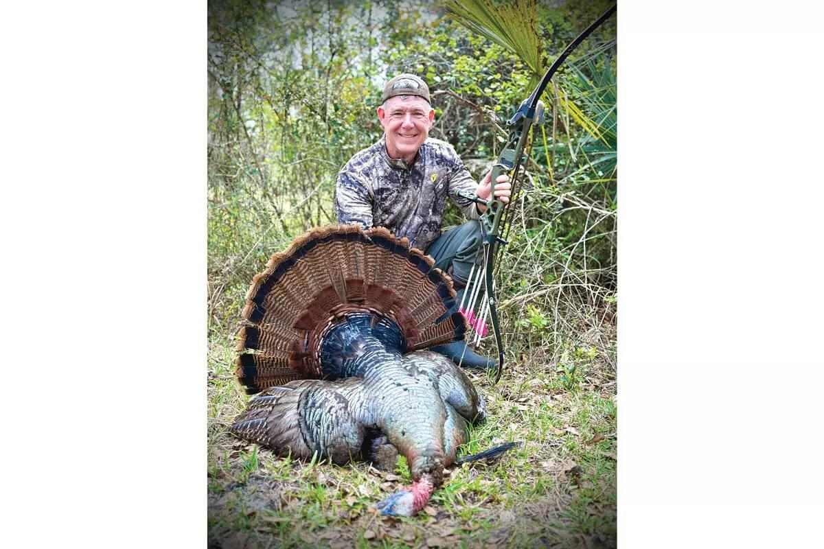 recurve hunter with downed Florida Osceola turkey
