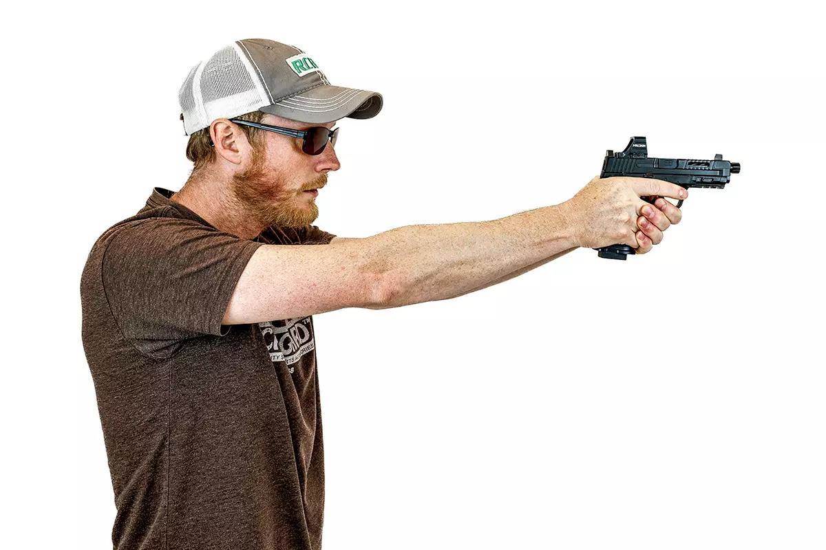 Author aiming a handgun using a two-handed grip