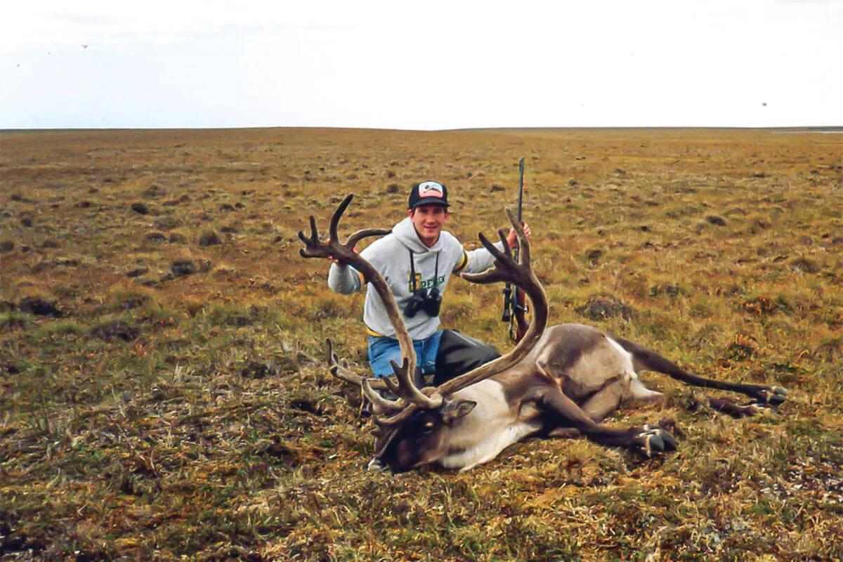 hunter with caribou bull