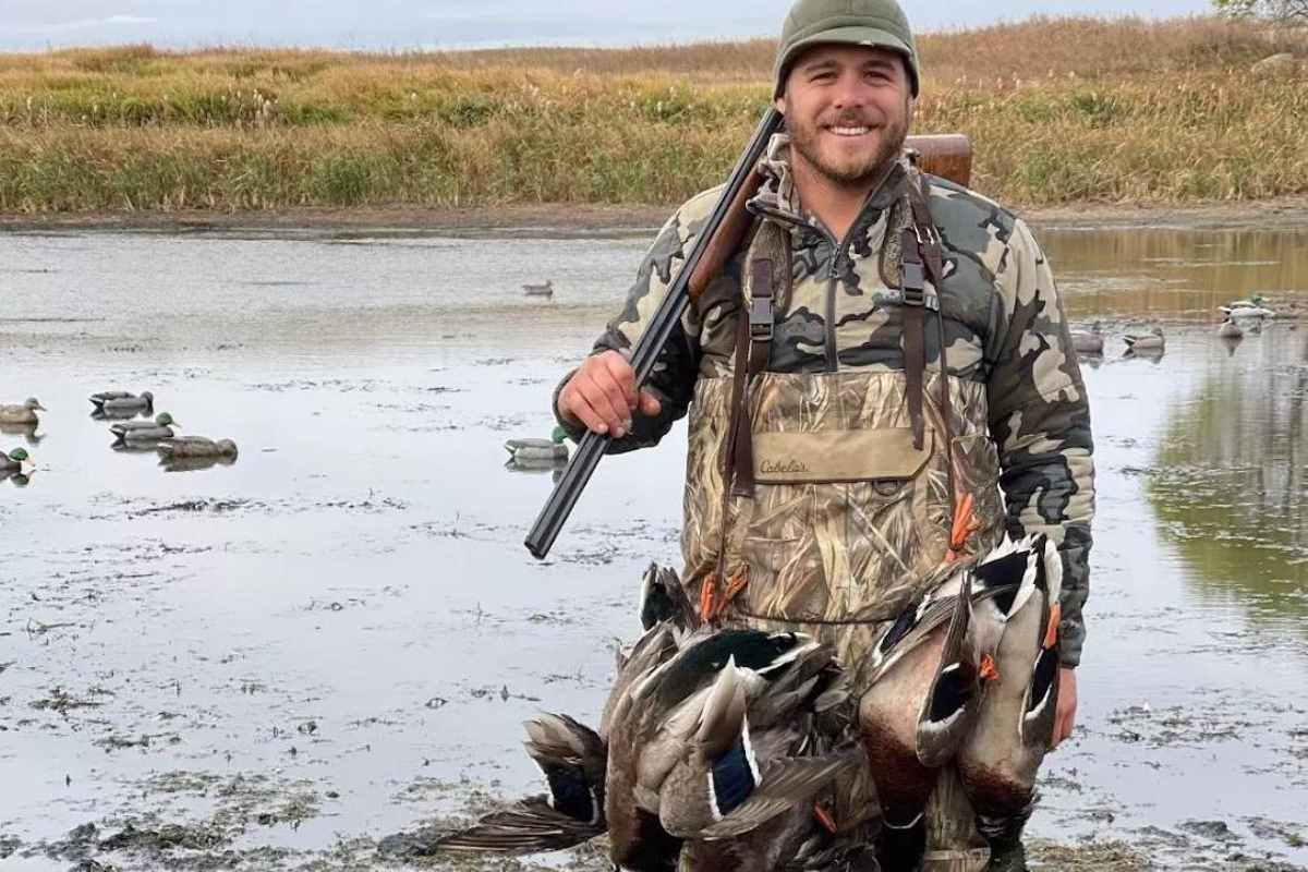 A hunter with a strap full of ducks.