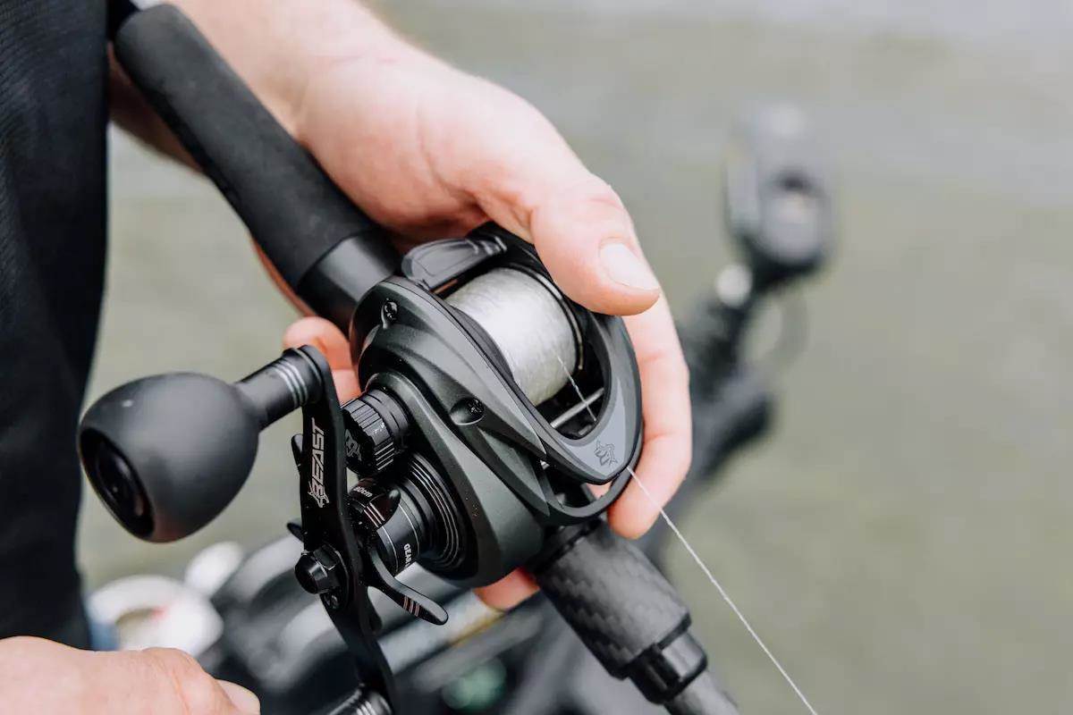 An angler holds a baitcasting rod and reel. 