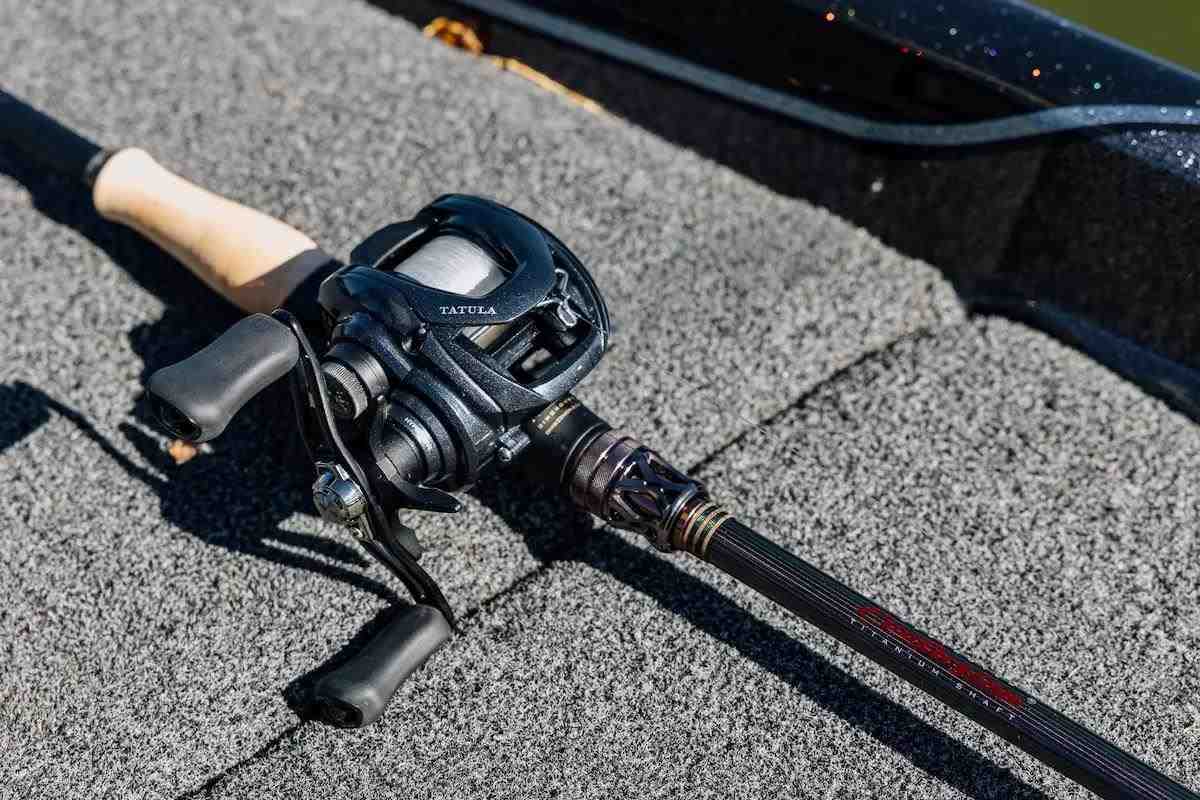 An angler holds a baitcasting rod and reel. 