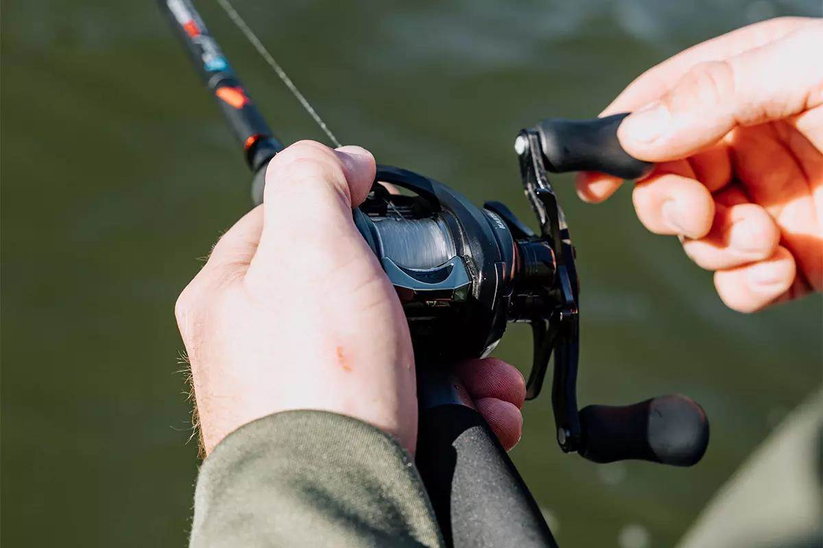 An angler holds a baitcasting rod and reel. 