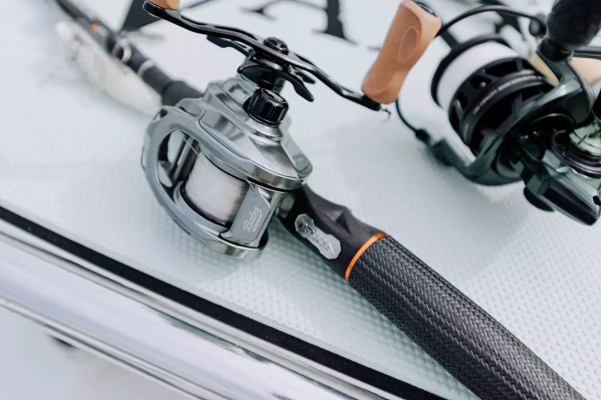 A baitcasting rod and reel lie on a bass boat deck.