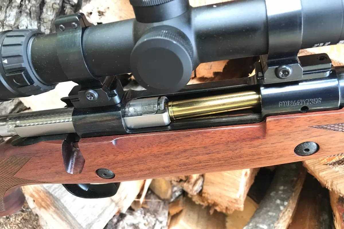 A close-up photo of a round being pushed into a rifle's chamber.