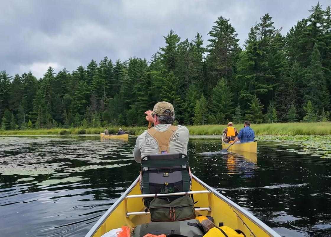 Two groups of canoers rowing through the Boundary Waters.