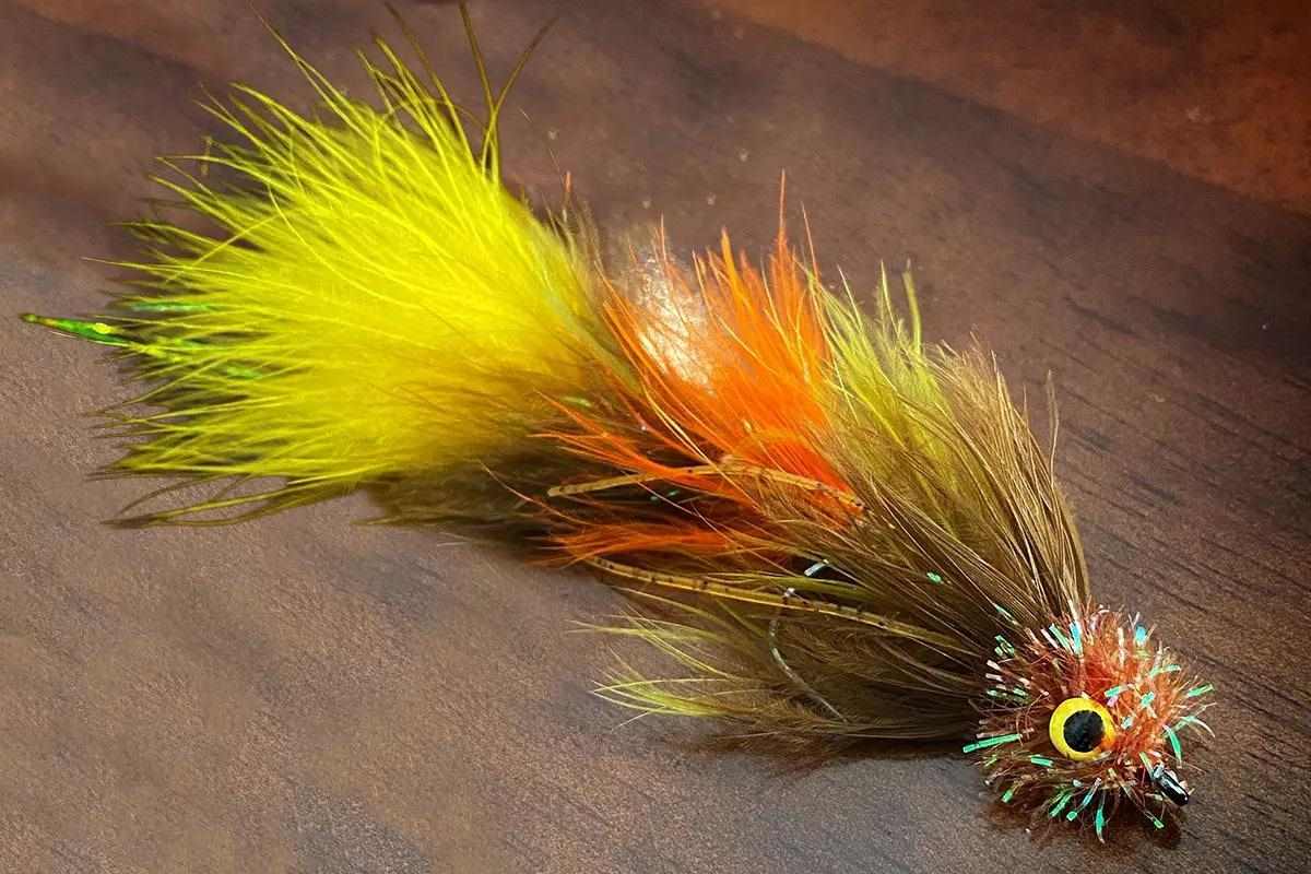 A Circus Peanut streamer fly on a wood table. 