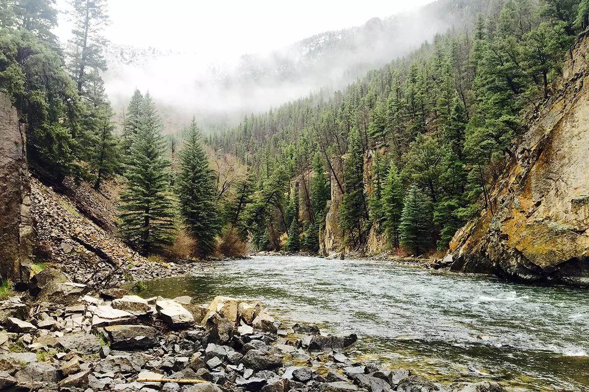 A river in a canyon on a foggy day.