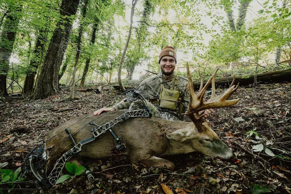 side profile of big Virginia whitetail buck with bowhunter