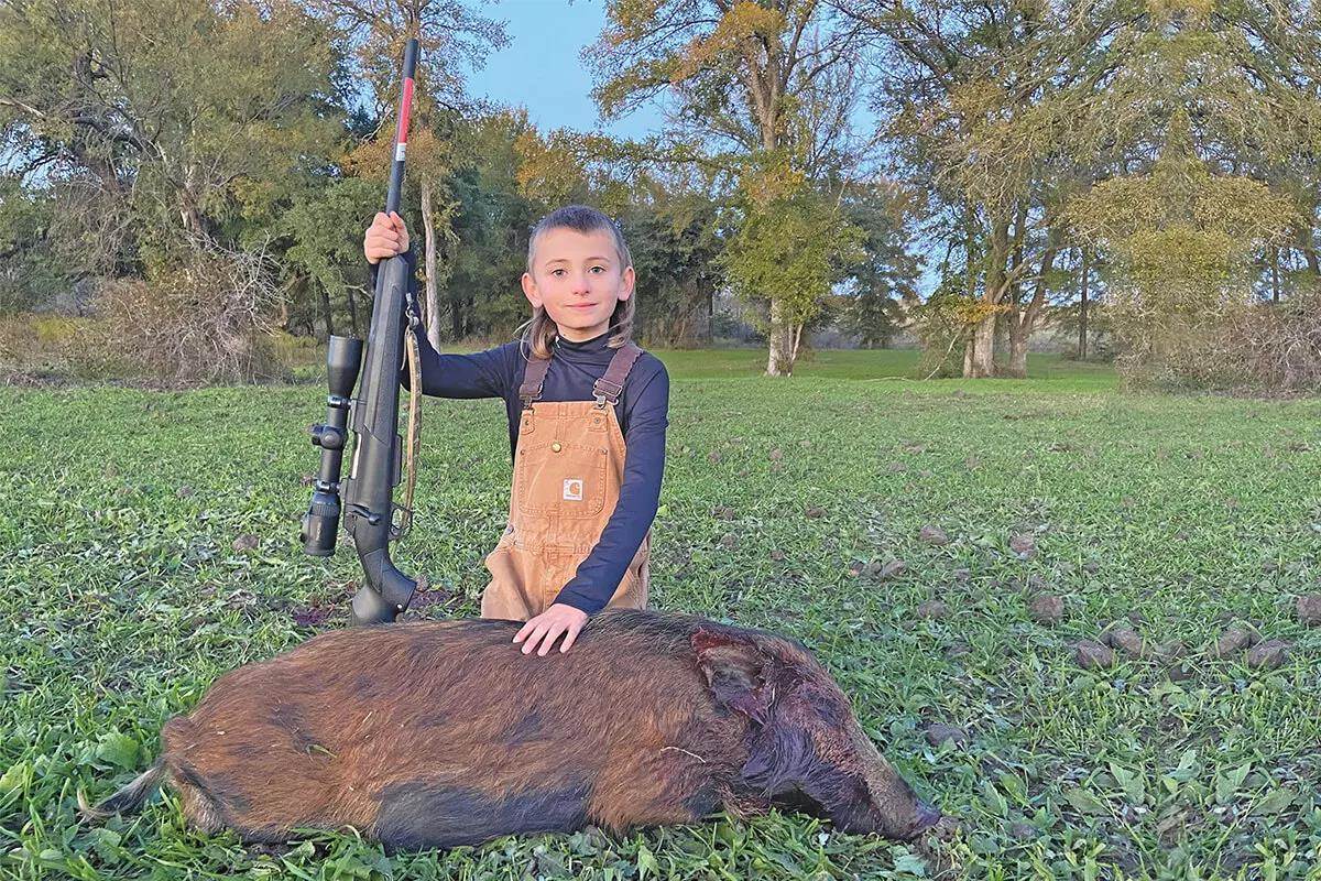youth hunter with hog