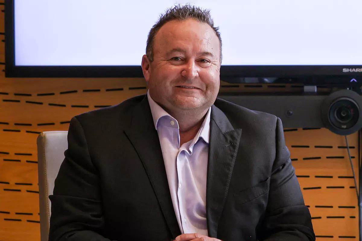man seated wearing sport coat and dress shirt