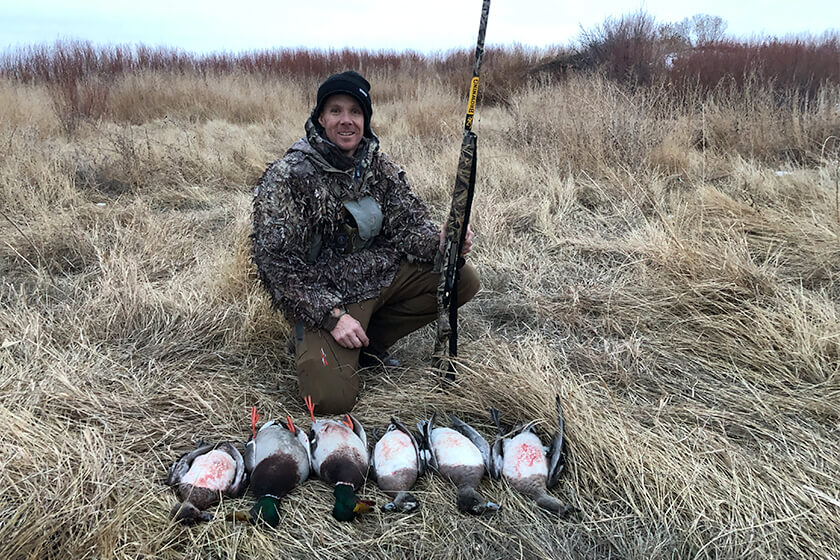 Hunter with a pile of ducks